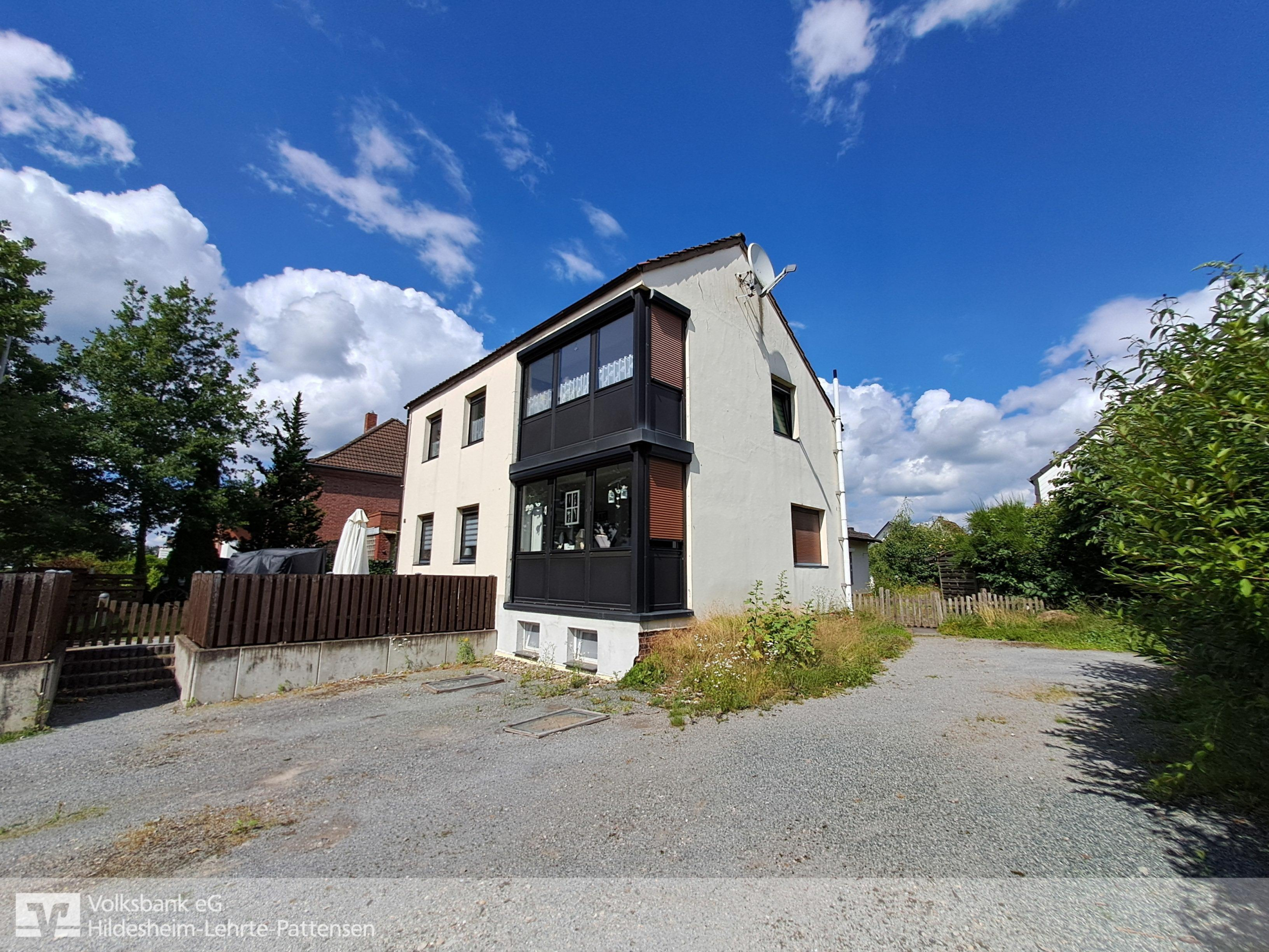 Frontansicht mit Zufahrt - Lehrte – Ahlten: Einfamilienhaus mit Bungalow-Anbau und großem Garten